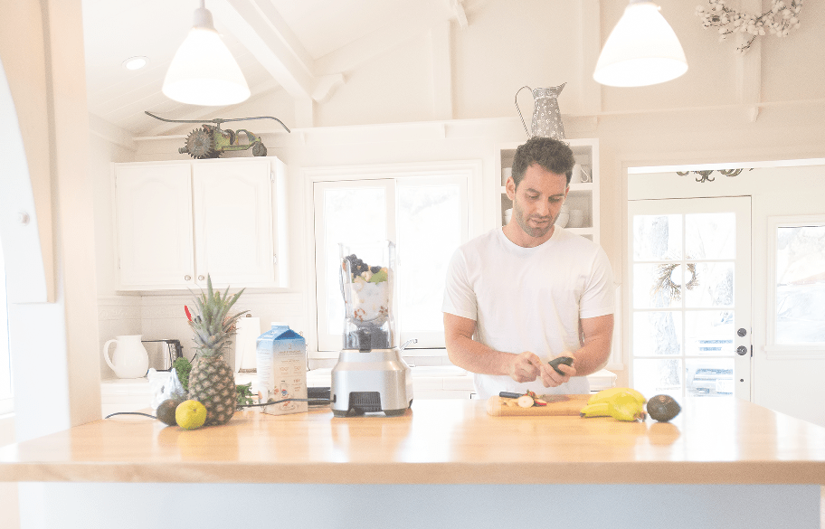 man making a smoothie in the kitchen