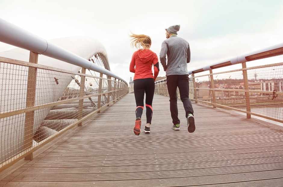 Two people running on a bridge