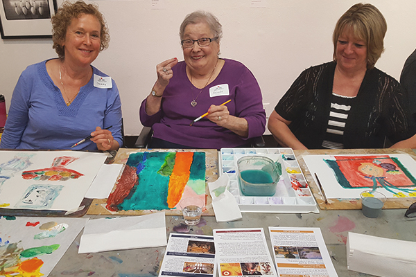 women painting and smiling