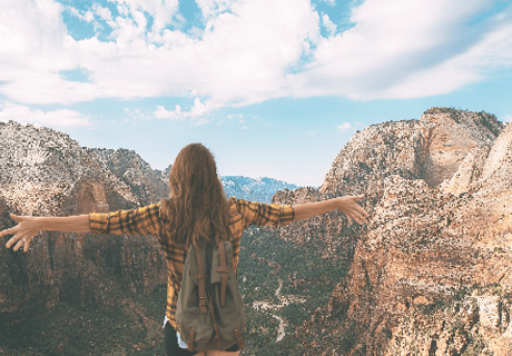 woman on a hike standing above mountains