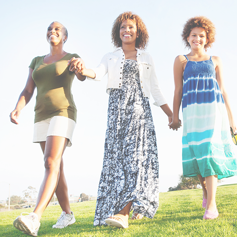 grandmother, mother and daughter walking in a park