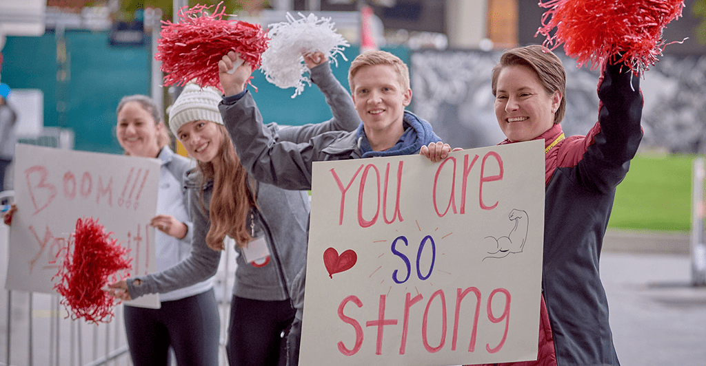 volunteers holding inspiration signs and cheering at Heart and Stroke Walk finish line