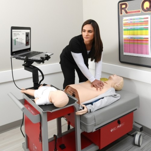 A woman practicing CPR using an RQI 2020 trainer