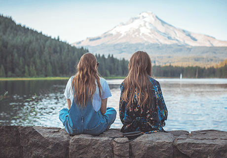 two girls over looking a lake