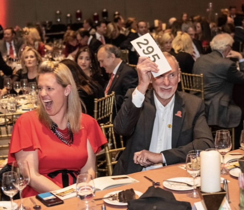 Robin Riley and Dwayne Laymon (both seated at center) take part in an auction at the 2019 Tulsa Heart Ball, one of many ways in which they've been involved with the American Heart Association. (American Heart Association)