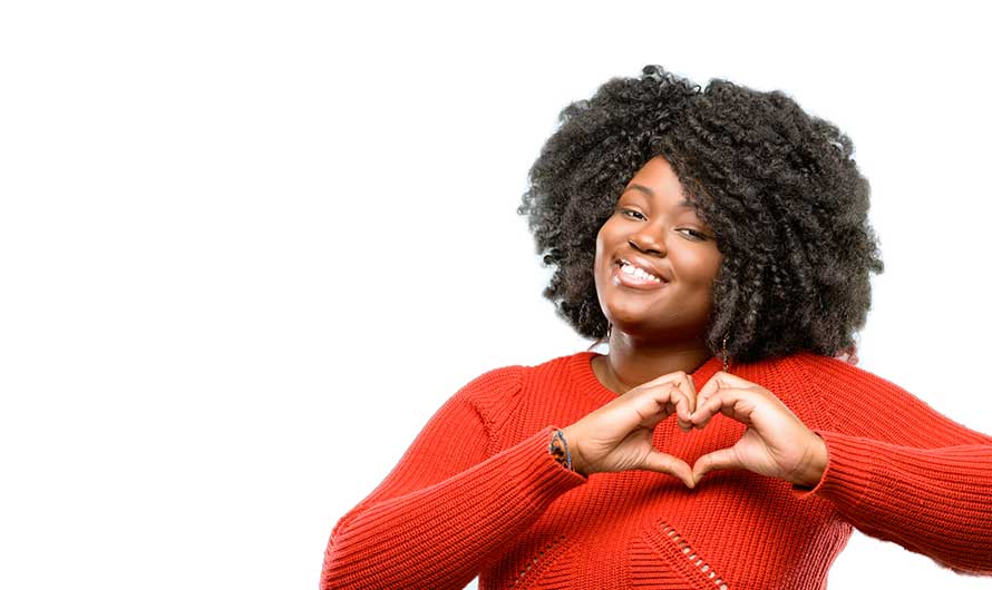 smiling woman making heart symbol with her hands