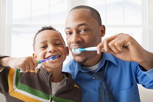 Father and son brushing teeth