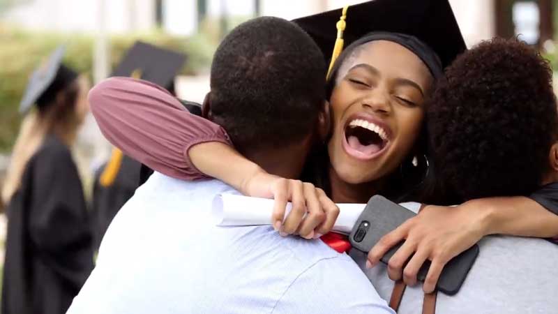 Still from COVID 19 Vaccine video of graduate hugging parents