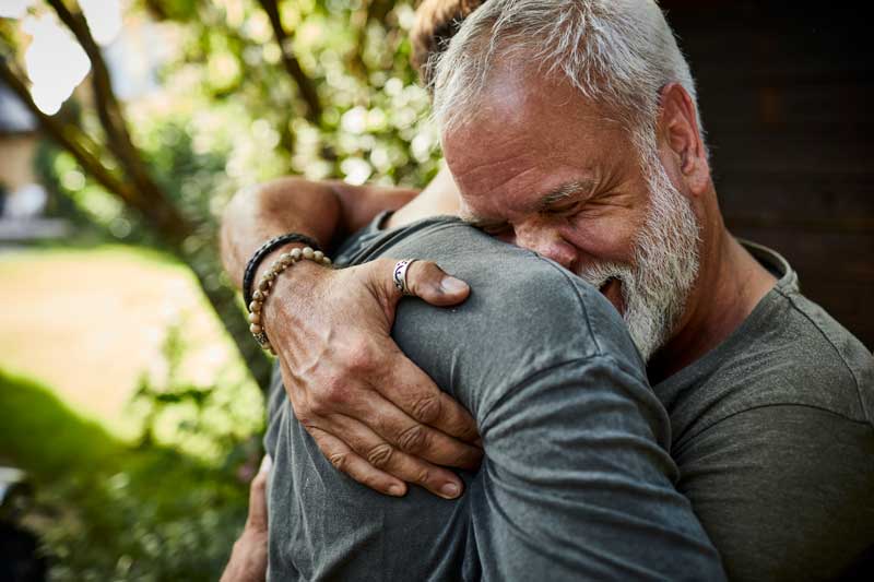 older man hugging son