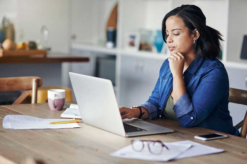 woman at table looking at laptop