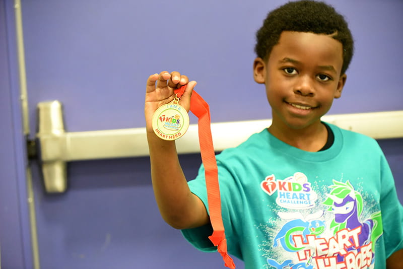young boy showing off medal