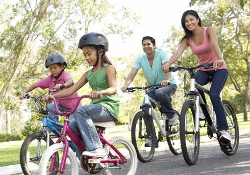 mom and dad with young daughter and son riding bicycles