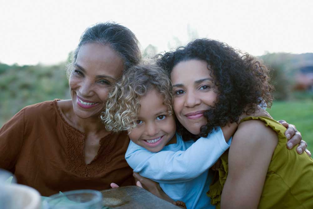 Mother and grandmother hugging child