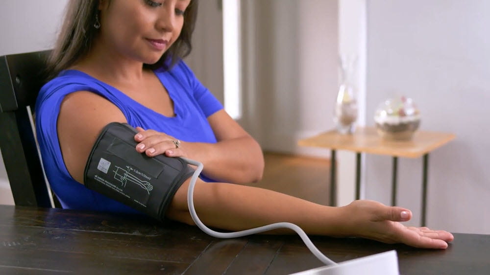 Woman checking blood pressure at home