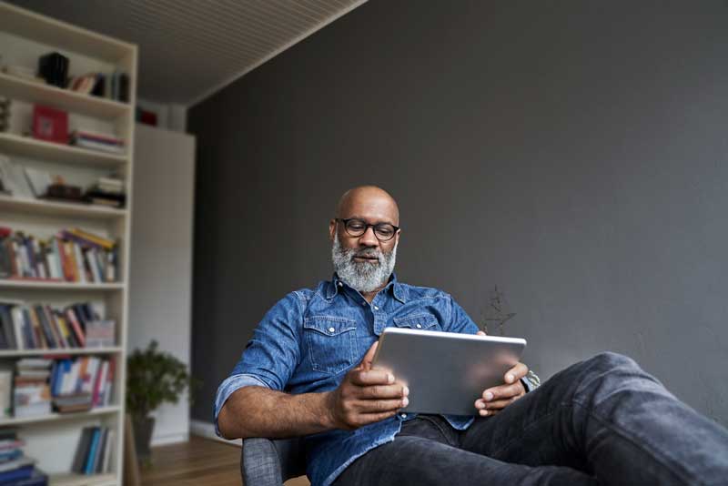 Man relaxing at home with his tablet