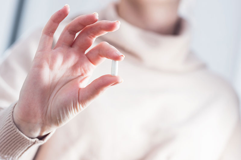 Woman holding a pill
