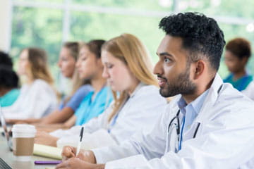 Group of health professionals sitting and taking notes in class
