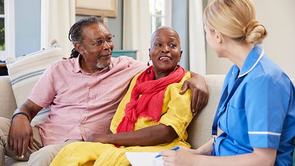 nurse talking to senior couple