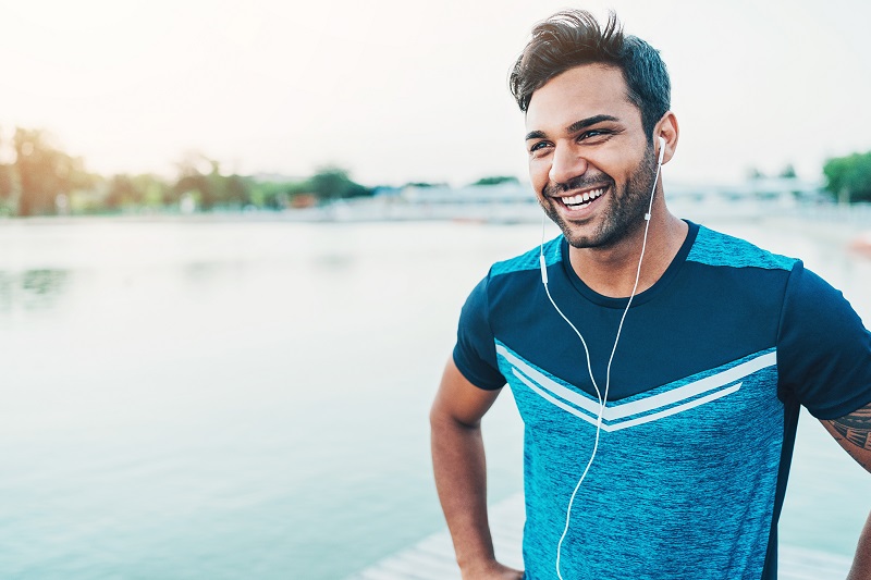 man exercising while listening to music and smiling
