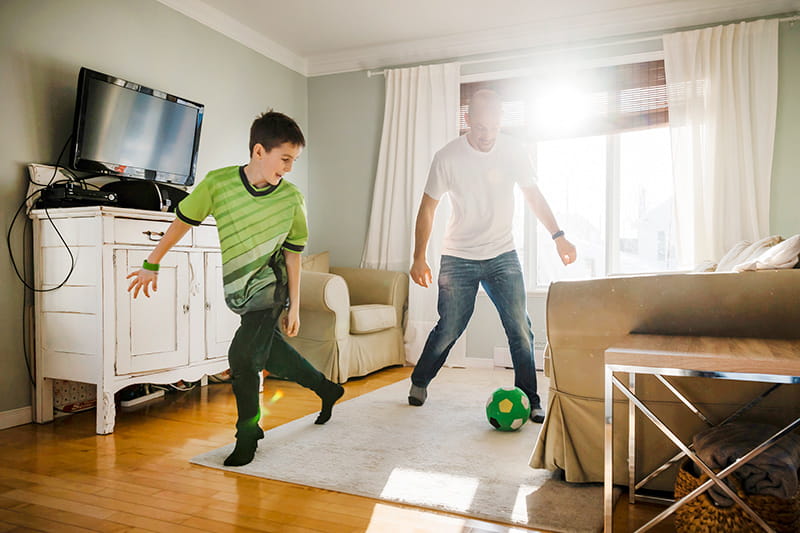 dad son play indoor soccer at home