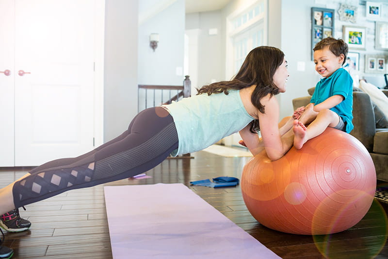 mom balancing baby on yoga ball