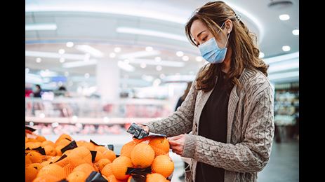 woman grocery shopping wearing mask