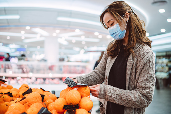 woman grocery shopping wearing mask