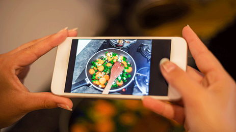 womans hands smart phone photographing food