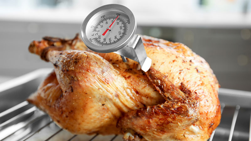 Checking the temperature with a meat thermometer to make sure the turkey  done Stock Photo