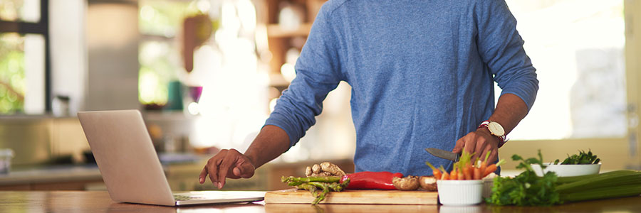 Man cooking recipe on laptop