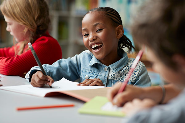 Student smiling at desk