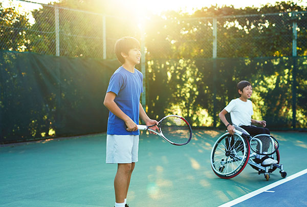 Teenager in wheelchair playing tennis