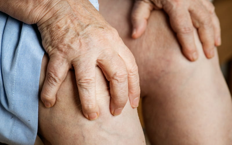 Elderly woman with knee pain (Rawpixel)
