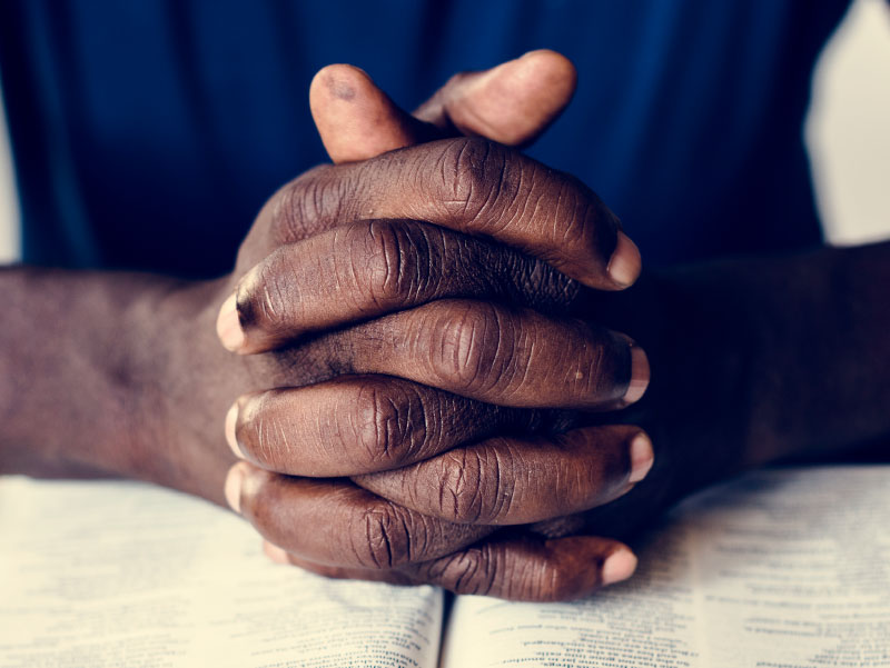African-American man's hands, praying. (Rawpixel, Envato Elements)