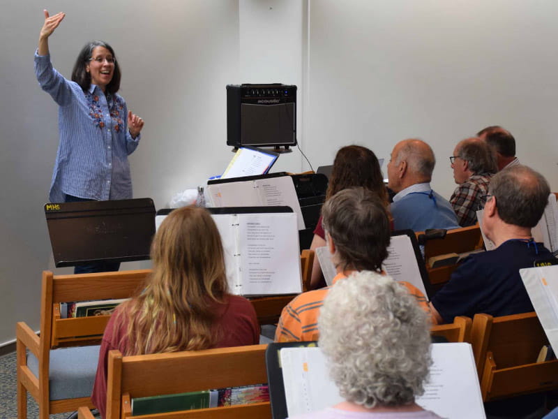 Karen McFeeters Leary, la patóloga del habla que fundó el Aphasia Choir of Vermont, dirige el ensayo del coro. (Foto cortesía de Karen McFeeters Leary)