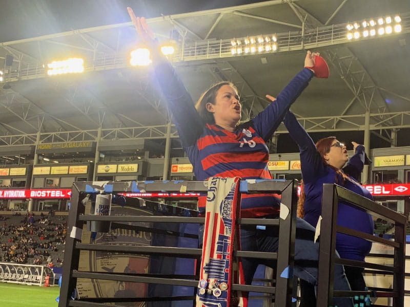 Crystal Cuadra-Cutler (left) leads fans in the stands in a chant during a soccer game in Carson, California, in 2021. (Photo courtesy of Rob Hendricks)