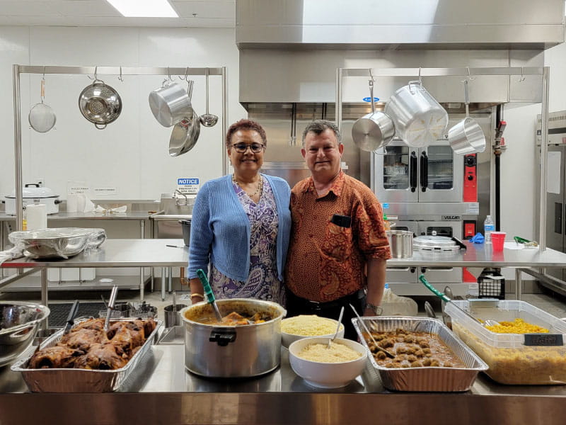 Naima Moustaid-Moussa (left) and her husband, Hanna Moussa, with food they cooked for international students at Texas Tech University. (Photo courtesy of Naima Moustaid-Moussa)