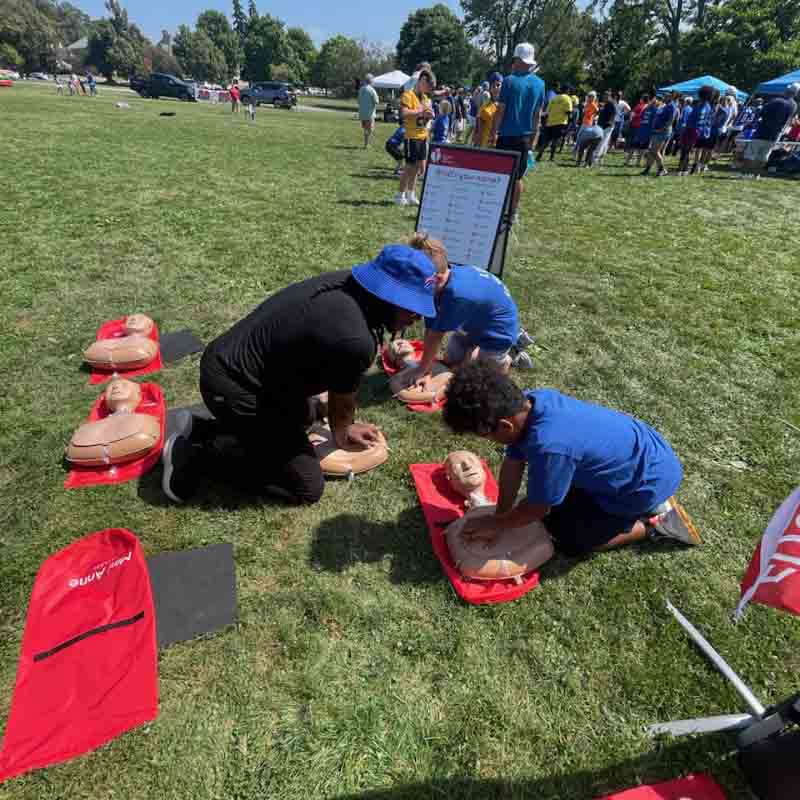 Alik Matthews le demuestra a un grupo de niños cómo hacer RCP usando solo las manos durante el campo de entrenamiento de los Buffalo Bills en Rochester, Nueva York, en agosto pasado. (Foto cortesía de Alik Matthews)