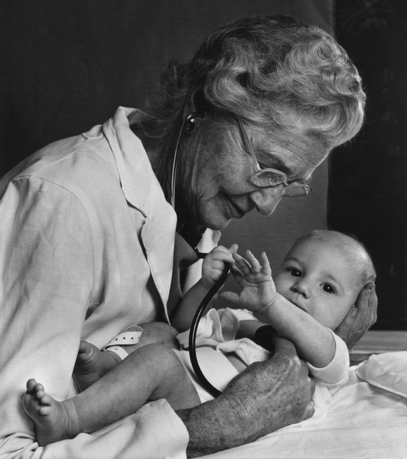 In this 1975 photo, Dr. Helen Taussig poses with a stethoscope on an infant. In real life, Taussig had little use for the instrument because of her hearing loss. (Photo by Yousuf Karsh)