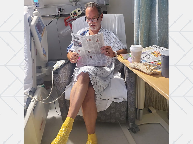 Michael Bonnardi reading a newspaper while recovering in the hospital