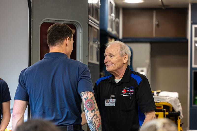 Karl greets firefighter Logan Lehrer, a student in the EMT class. 