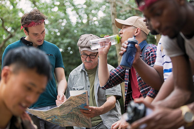 a group of hikers taking a water break while reviewing a map