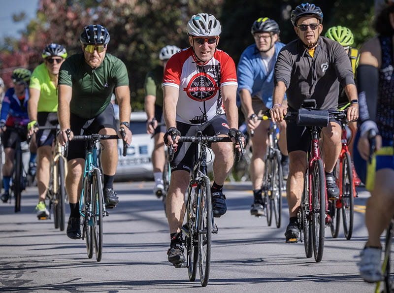 Patrick in a red and white jersey starts a cycling event in New York.