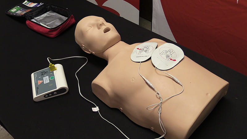 a CPR manikin and other equipment set up for display on a table