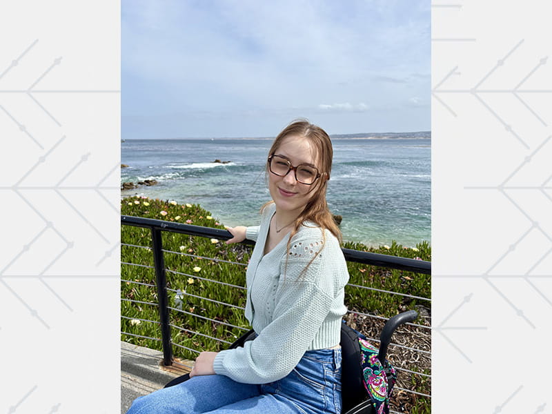 Caroline Laubach smiling and posing in the sunshine near the ocean