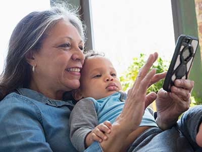 Hispanic woman with baby looking at smart phone
