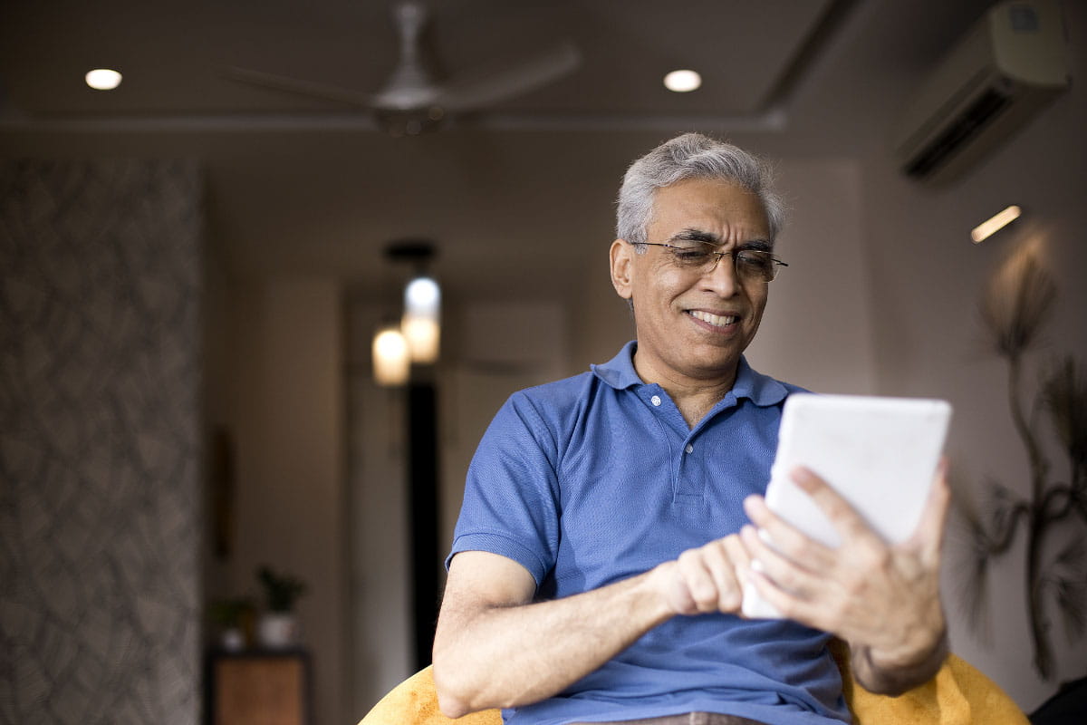 Senior Indian man reading a digital tablet
