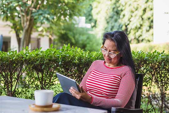 Portrait of Asian woman using digital tablet computer at home outdoors