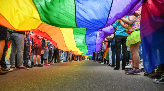 Group of people walking with rainbow parachute