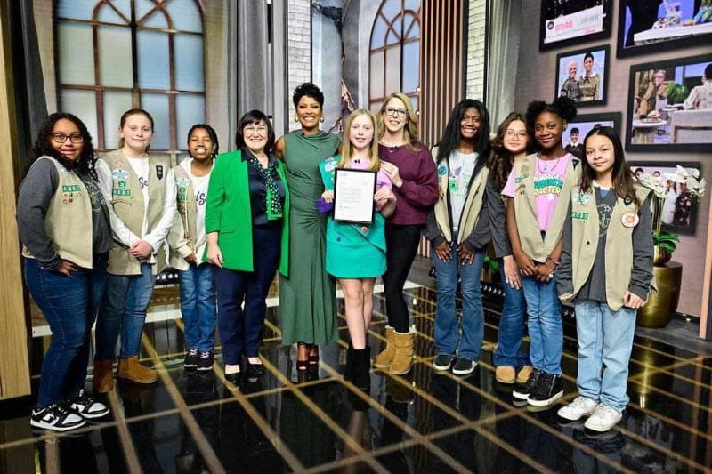 Vada, holding a letter about her Medal of Honor, and Amanda (maroon sweater), with Tamron Hall (green dress), a Girl Scouts executive (green jacket), and other Girl Scouts Medal of Honor recipients on the set of the Tamron Hall Show. (Tamron Hall Show photo courtesy of Carawan family)